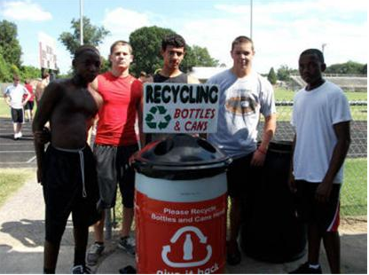 Guys pose with Recycle Cans and Bottles sign